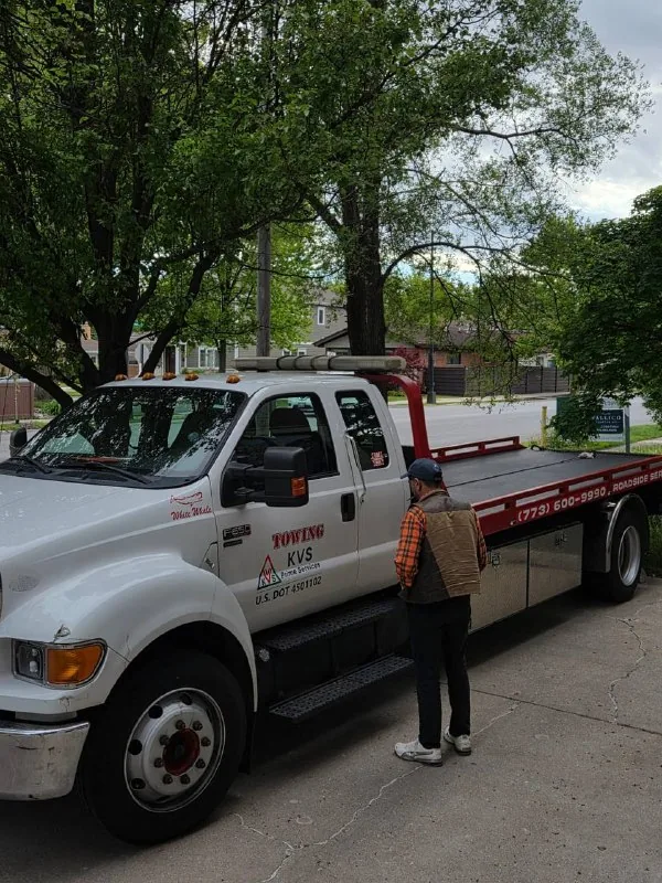 KVS Prime Services Ford F-650 flatbed with the operator standing beside the empty deck