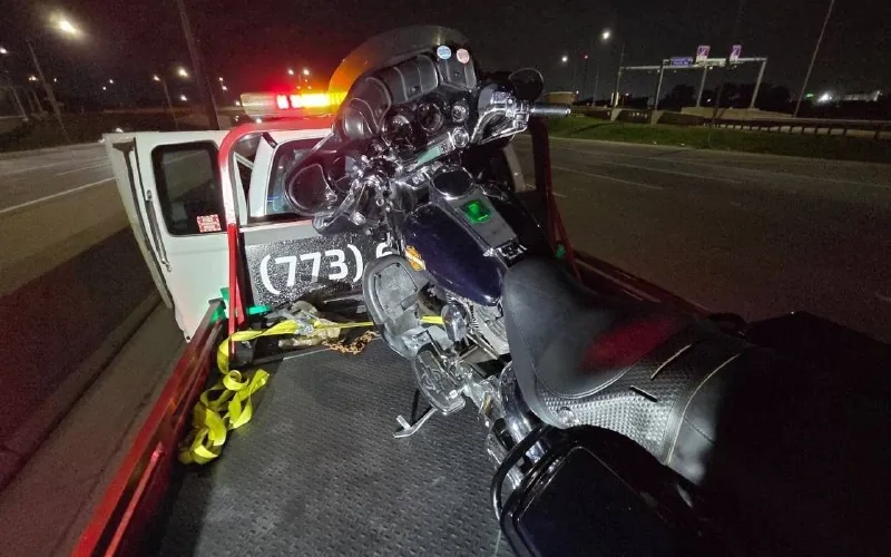 Harley-Davidson touring bike chocked and strapped down on the KVS flatbed at night